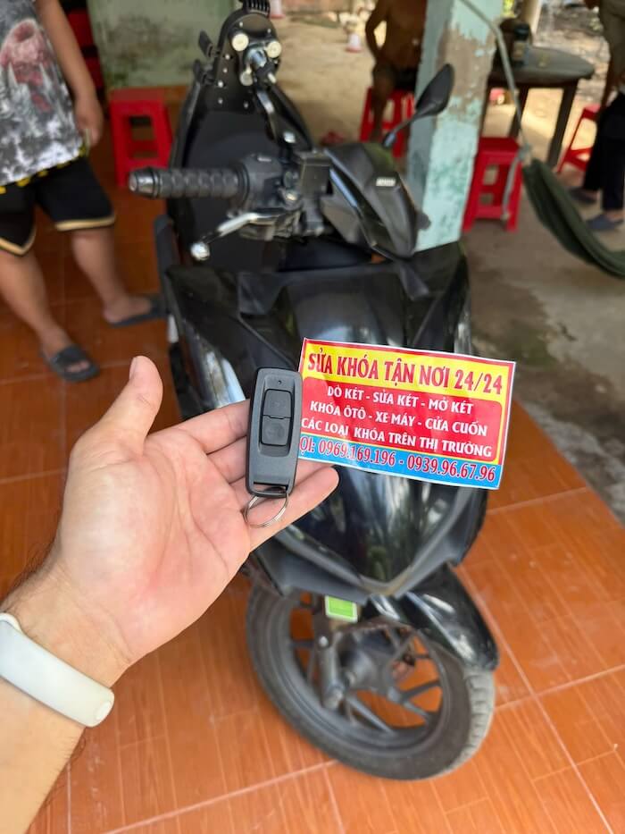 thợ sửa khóa xe máy đang làm lại chìa smartkey